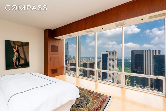 bedroom featuring hardwood / wood-style floors, a wall of windows, and access to exterior