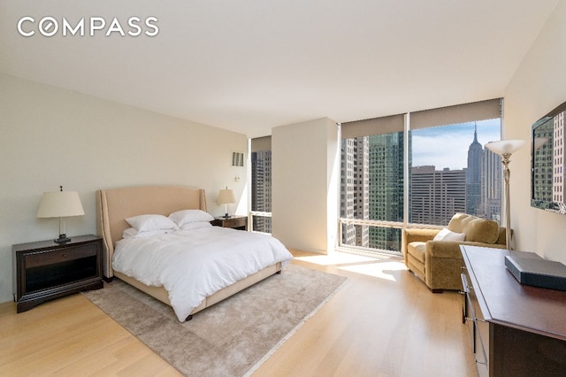 bedroom featuring light hardwood / wood-style flooring and expansive windows