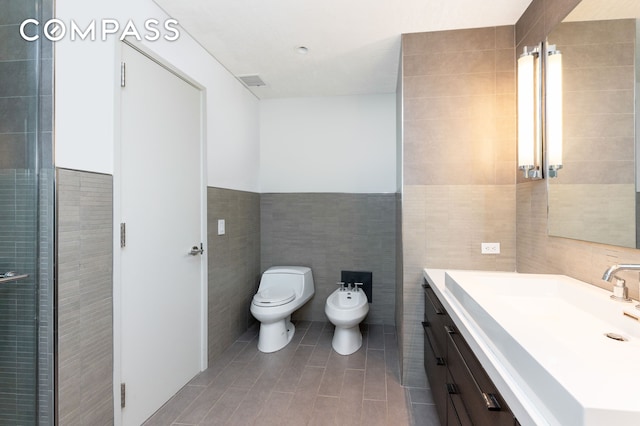 641 5th Ave Unit 49Cde, New York City, NY 10022 - bathroom featuring tile walls, a bidet, vanity, and tile patterned flooring