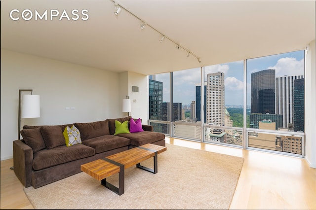 641 5th Ave Unit 49Cde, New York City, NY 10022 - living area with wood finished floors, track lighting, a view of city, and floor to ceiling windows