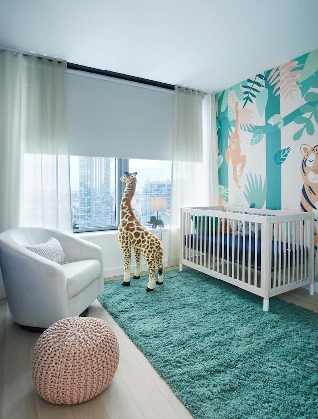 bedroom featuring a crib and wood finished floors