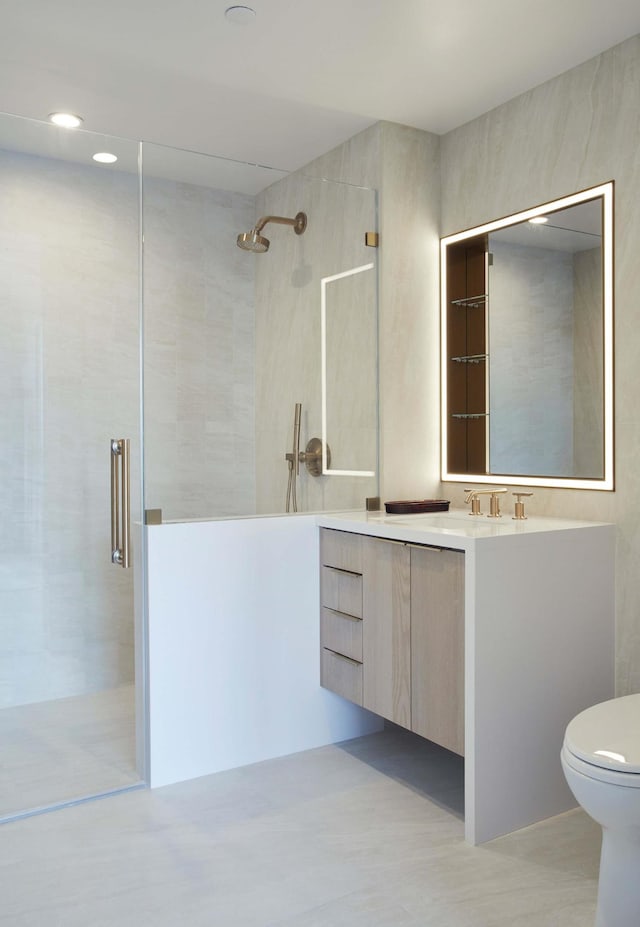 bathroom with vanity, a shower stall, and toilet