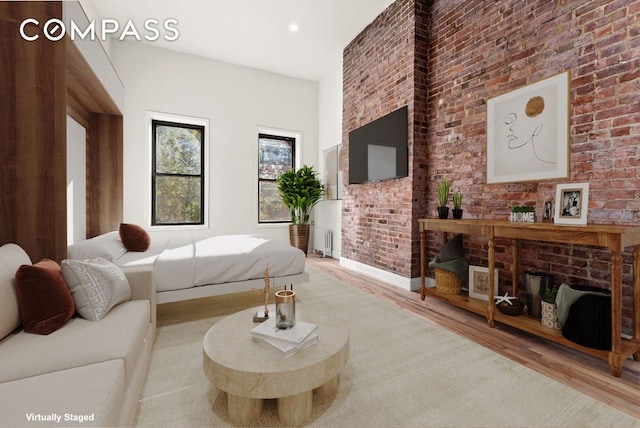 bedroom featuring brick wall and light wood-type flooring