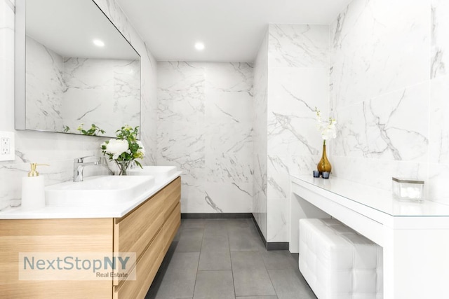 bathroom featuring vanity and tile walls