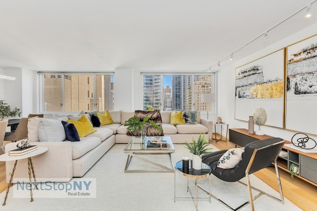 living room featuring track lighting, a city view, and wood finished floors