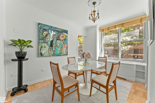 dining space with baseboards, a chandelier, and crown molding