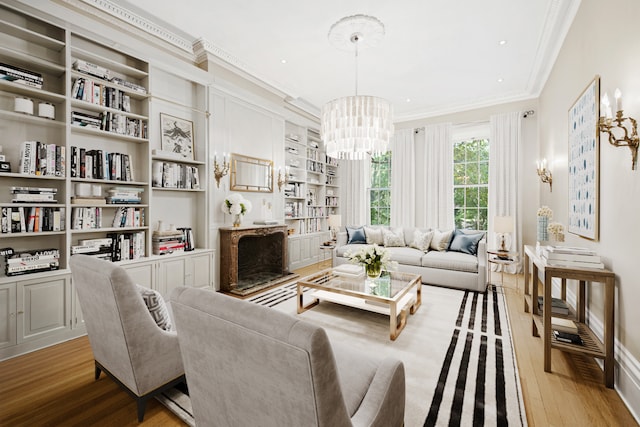 26 Washington Sq N, New York City, NY 10011 - living area with crown molding, wood finished floors, a chandelier, a fireplace with raised hearth, and built in shelves