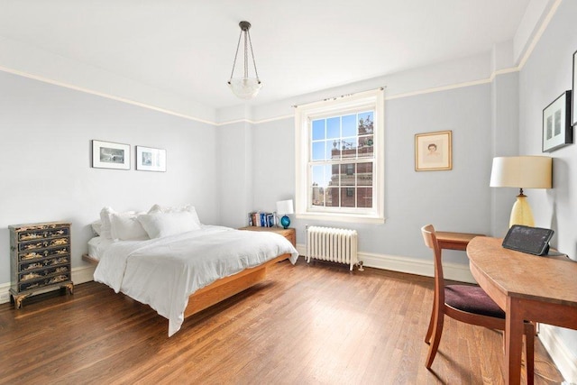 bedroom with dark wood-type flooring and radiator heating unit