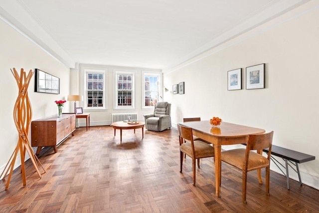 sitting room with radiator heating unit, ornamental molding, and light parquet flooring