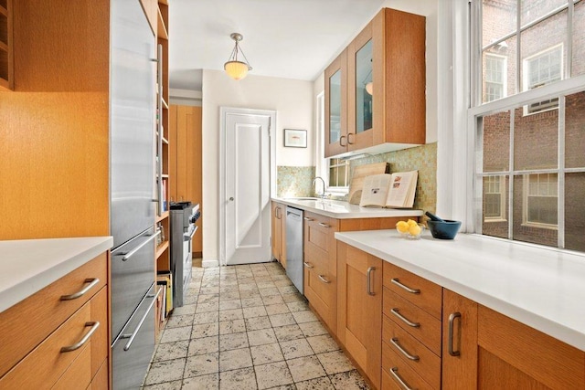 kitchen with decorative light fixtures, decorative backsplash, premium appliances, and sink