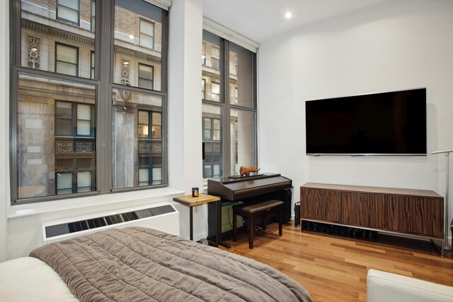 bedroom featuring radiator heating unit and wood finished floors