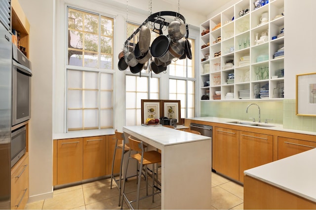 kitchen with a peninsula, open shelves, a sink, light countertops, and backsplash