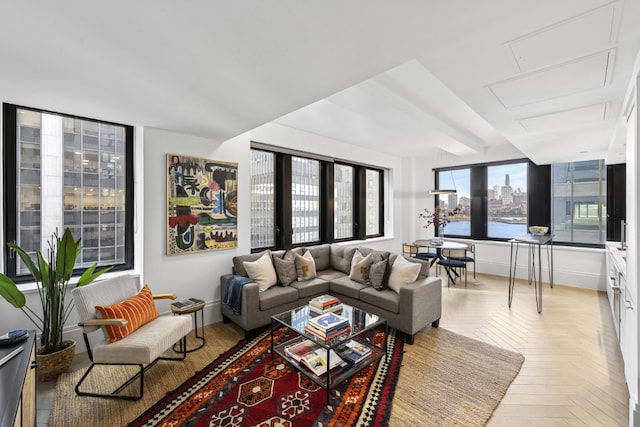 living room with a wealth of natural light, light parquet flooring, and a water view