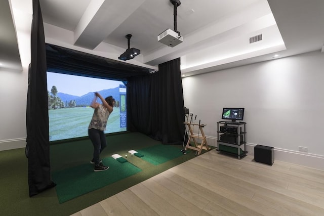 recreation room with baseboards, visible vents, golf simulator, and wood finished floors