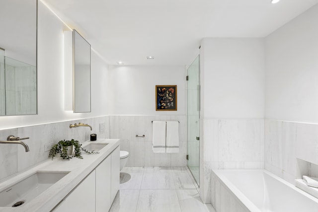 full bathroom featuring toilet, a shower stall, a sink, and a bath