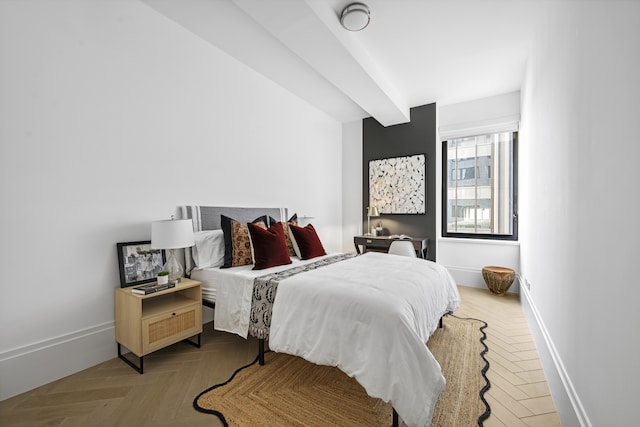 bedroom featuring beam ceiling and baseboards