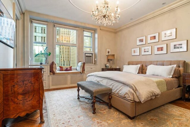 living room featuring an inviting chandelier, wood-type flooring, and crown molding