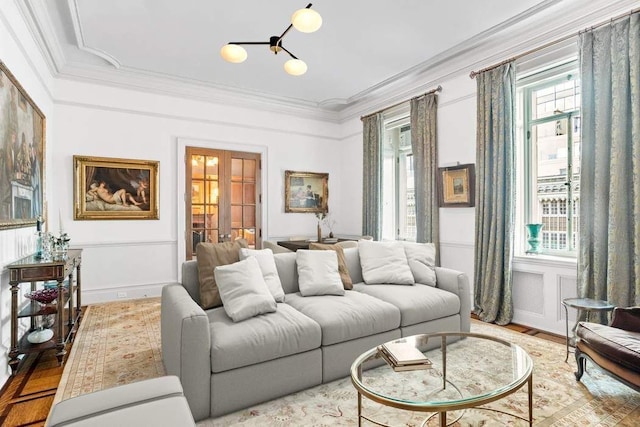 living room featuring crown molding, plenty of natural light, light hardwood / wood-style floors, and french doors