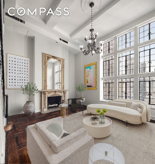 living room featuring an inviting chandelier, beam ceiling, wood-type flooring, and a high ceiling