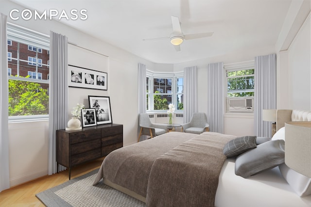 bedroom featuring ceiling fan, multiple windows, and cooling unit