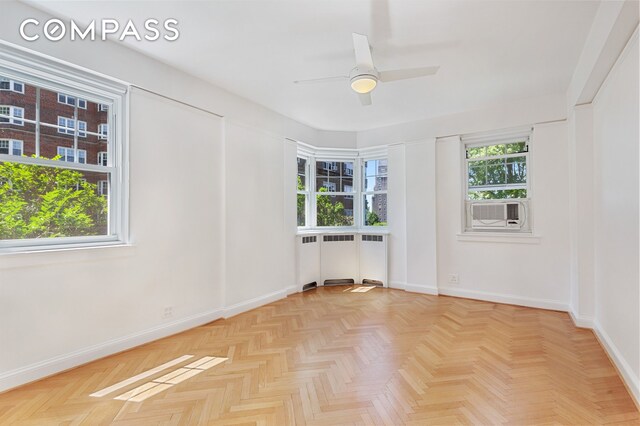 spare room with ceiling fan, cooling unit, and baseboards