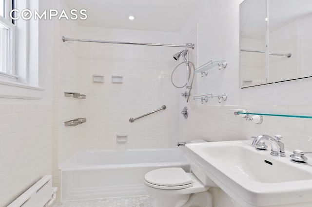 bathroom featuring shower / washtub combination, a wainscoted wall, tile walls, toilet, and a baseboard heating unit