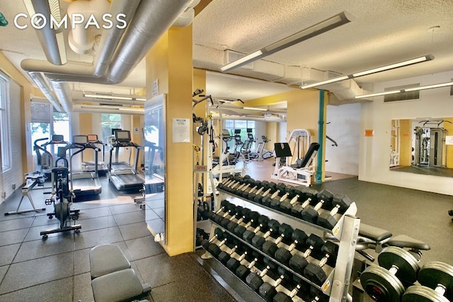 exercise room featuring a healthy amount of sunlight and a textured ceiling