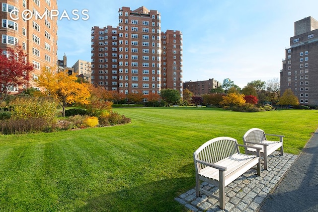 view of property's community with a view of city and a yard