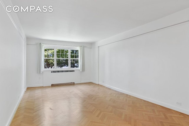 empty room featuring light parquet floors and radiator