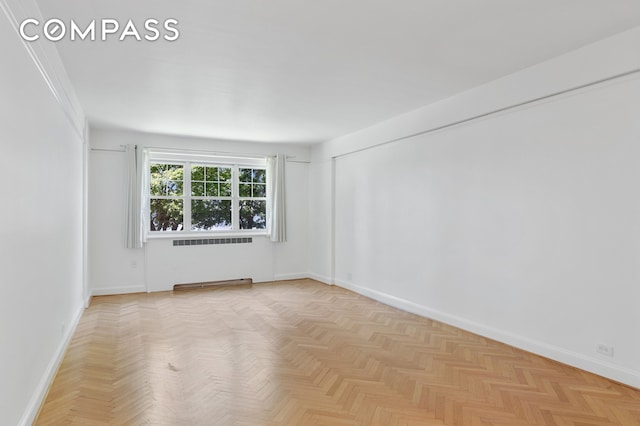 empty room with baseboards and radiator heating unit