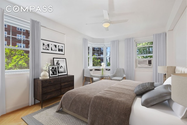 bedroom featuring cooling unit, ceiling fan, and light parquet flooring