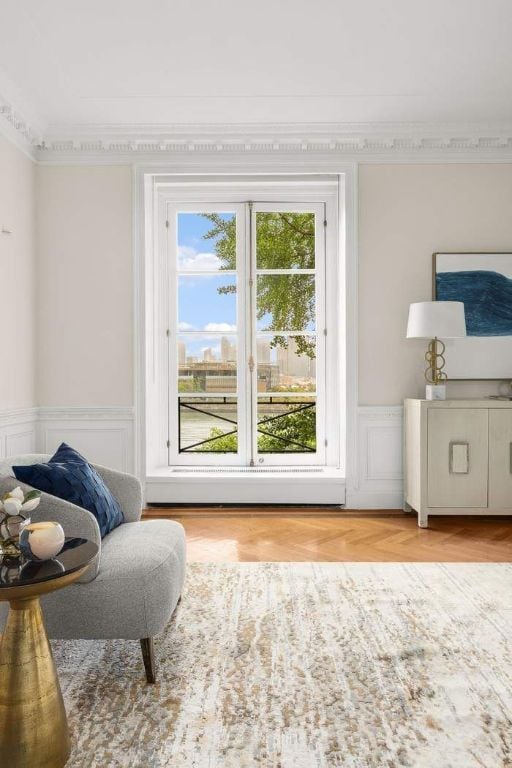 sitting room with light parquet floors and crown molding