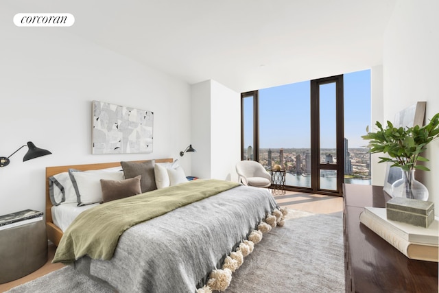 bedroom featuring expansive windows, access to outside, and visible vents