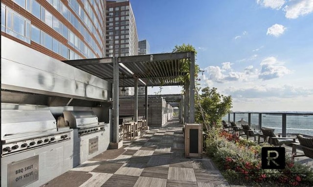 view of patio / terrace featuring area for grilling, a water view, and a grill