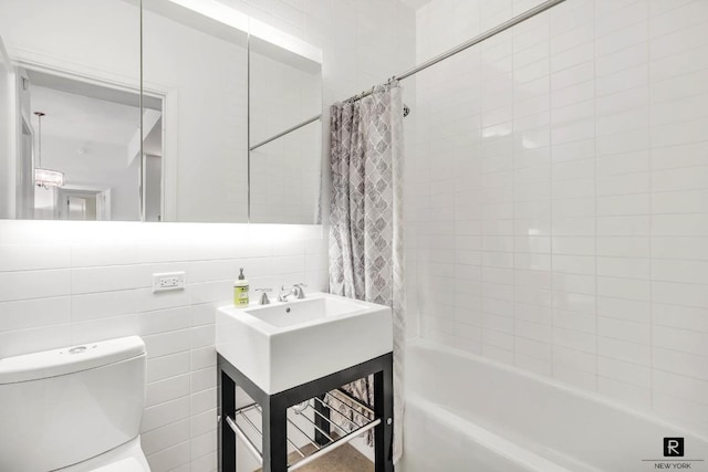 bathroom featuring toilet, backsplash, shower / bath combo with shower curtain, and tile walls