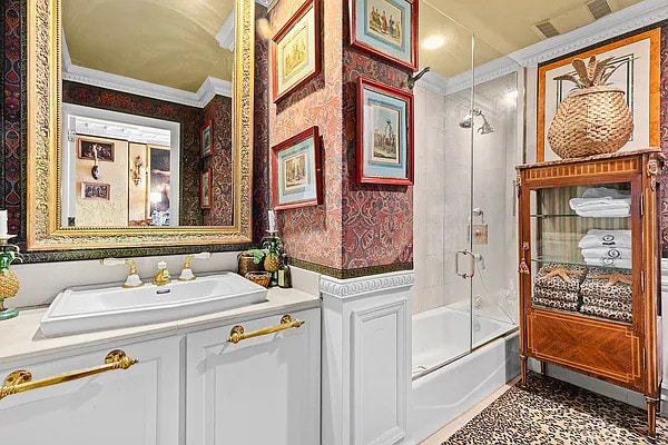 bathroom with combined bath / shower with glass door, vanity, and crown molding