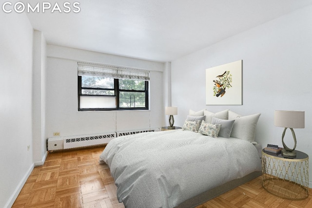 bedroom with light parquet flooring and baseboard heating