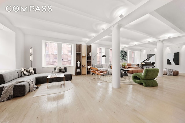 living room featuring decorative columns, beamed ceiling, and light wood-type flooring