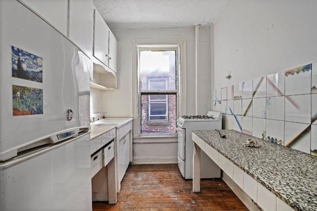 kitchen with sink, white range with gas stovetop, a textured ceiling, dark hardwood / wood-style flooring, and white cabinets