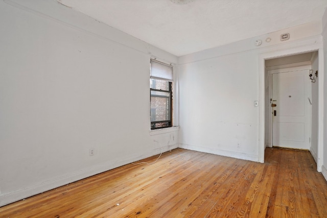 empty room with light wood-type flooring and baseboards