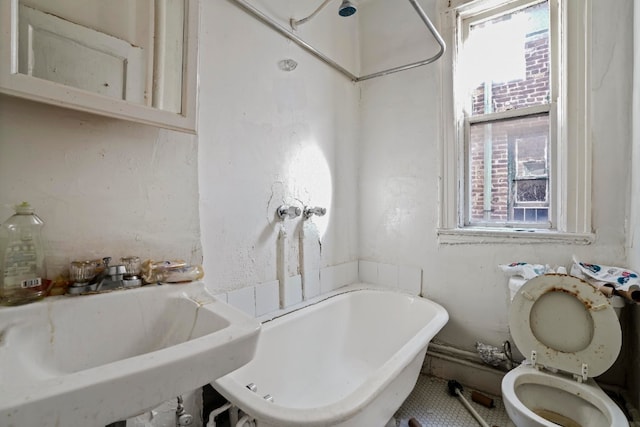 bathroom with toilet, a bathing tub, and sink