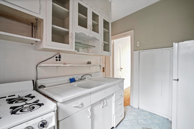 kitchen featuring white appliances, white cabinets, light floors, and light countertops