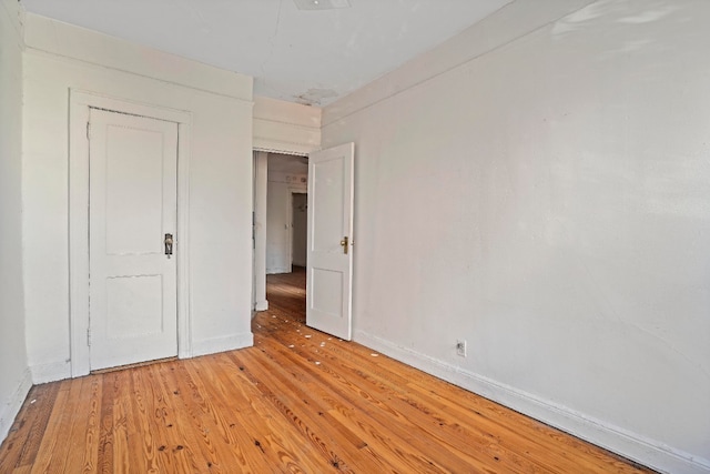 unfurnished bedroom featuring light wood-style flooring and baseboards