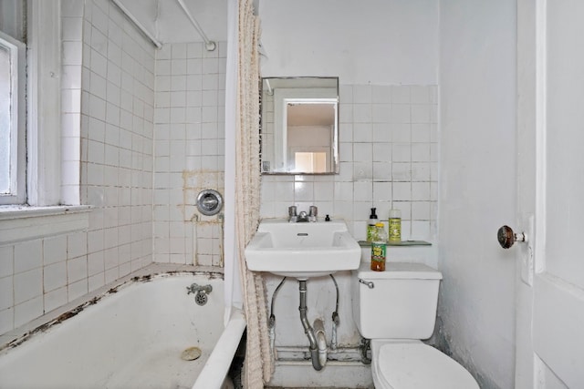 full bathroom with sink, tile walls, backsplash, tiled shower / bath combo, and toilet