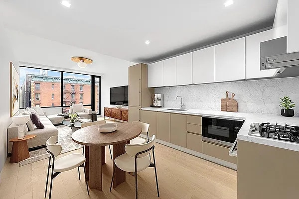 kitchen featuring a sink, light countertops, light wood-style floors, black microwave, and tasteful backsplash