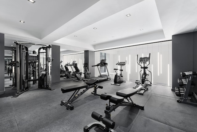 workout area featuring recessed lighting and a tray ceiling