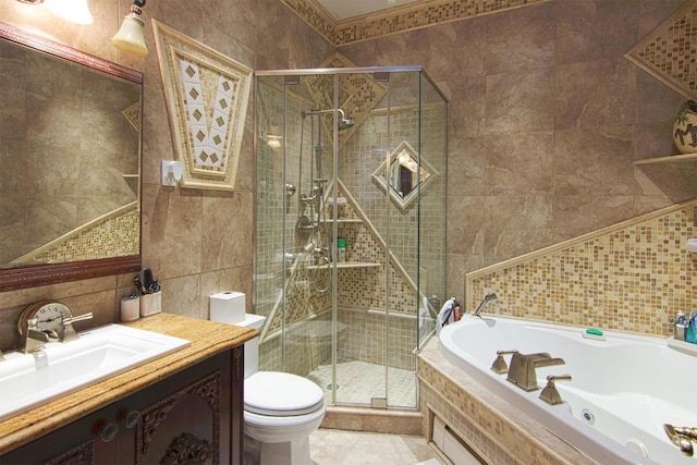 bathroom with a stall shower, toilet, a jetted tub, vanity, and tile walls