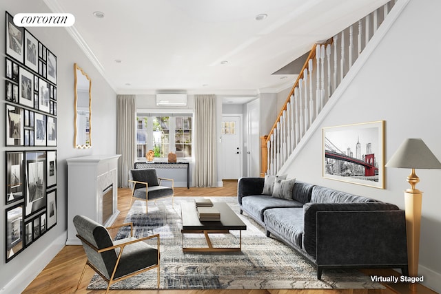 living room with stairway, an AC wall unit, crown molding, and wood finished floors