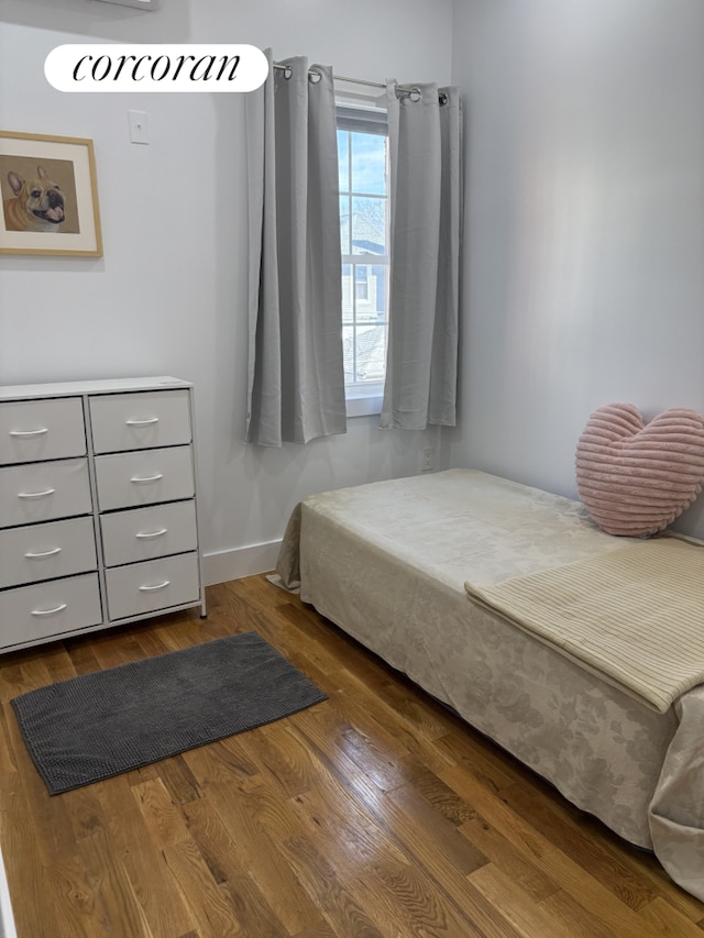 bedroom with wood finished floors and baseboards