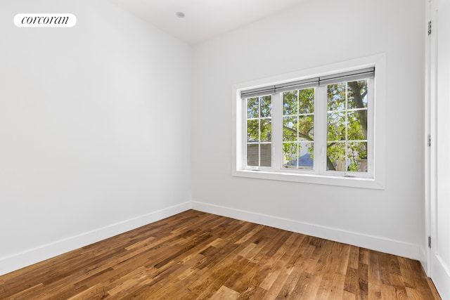 empty room featuring visible vents, baseboards, and wood finished floors